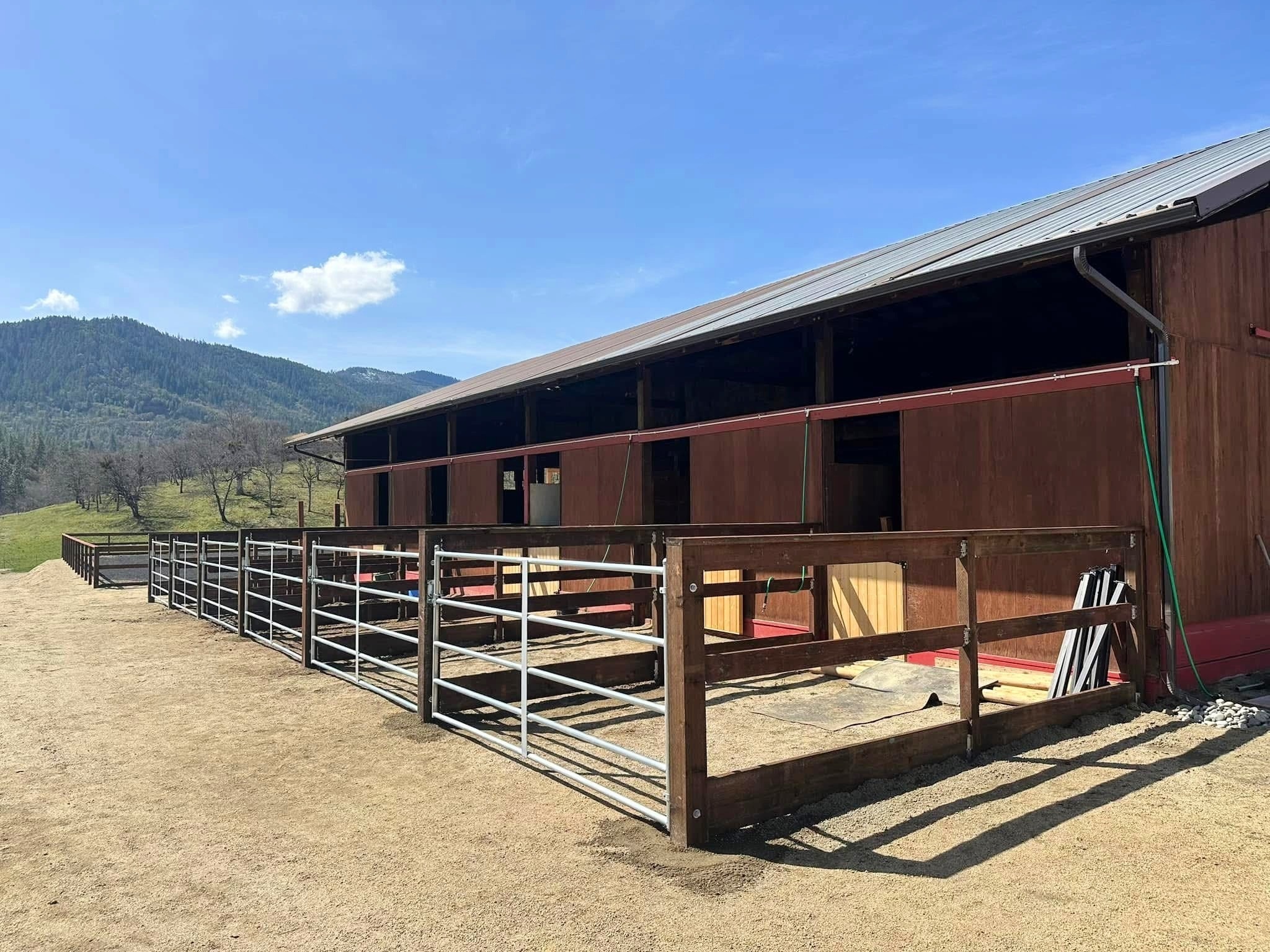 Three rail pressure treated horse corral with custom built gates in the Rogue Valley