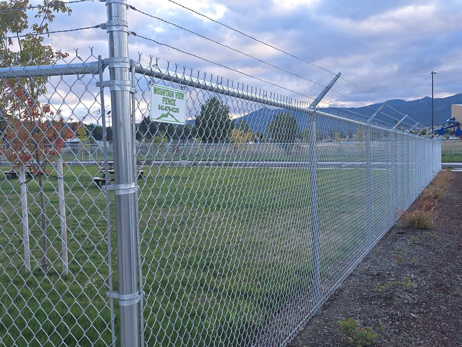 6' High Galvanized Chain Link Fence with 3 Strands of Barbed Wire on Top at a 45 Degree Angle