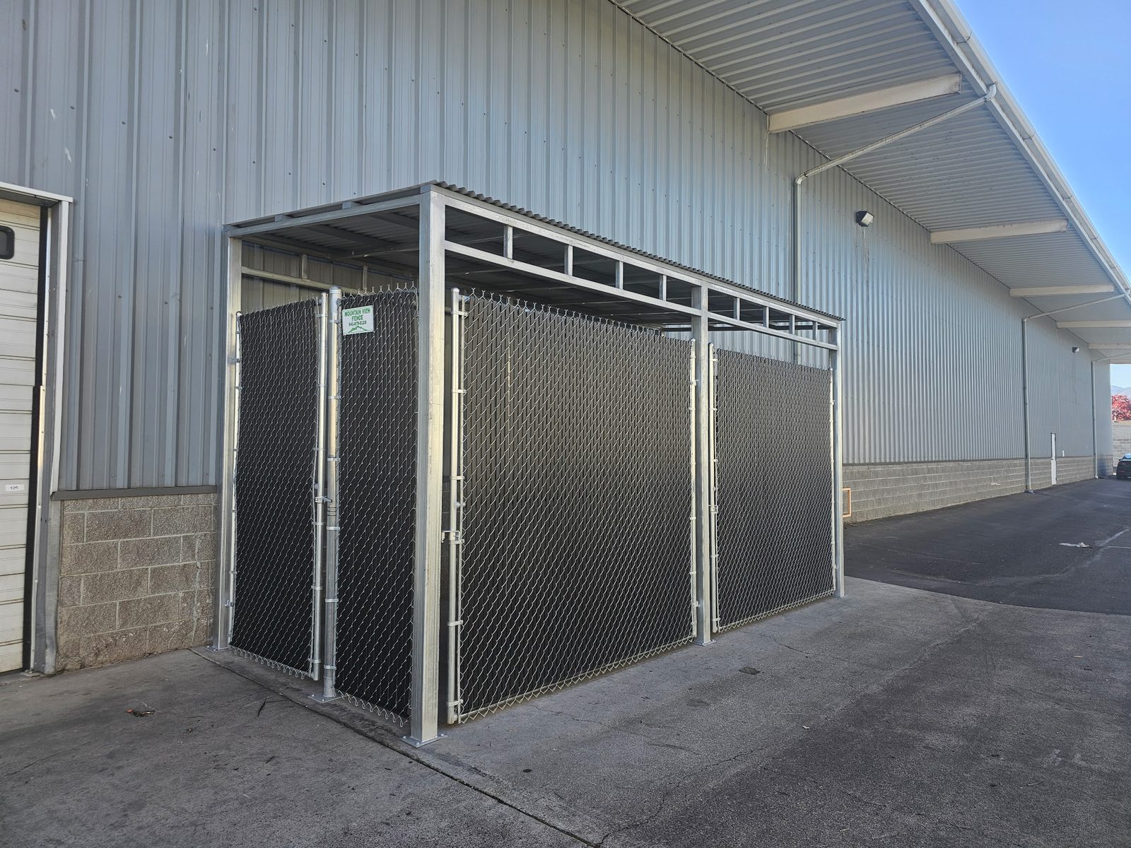 Chain Link Equipment Enclosure with Metal Roofing and Black Privacy Slats
