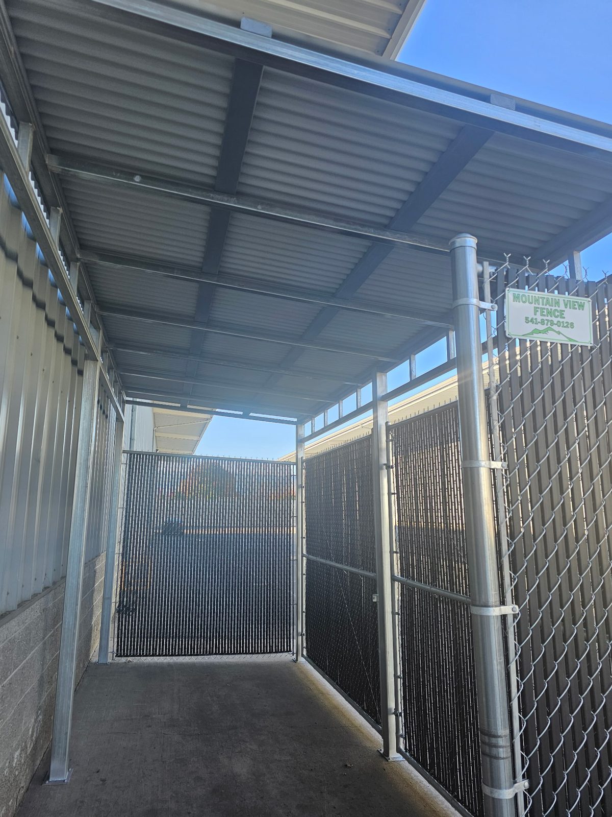 Chain Link Equipment Enclosure with Metal Roofing and Black Privacy Slats