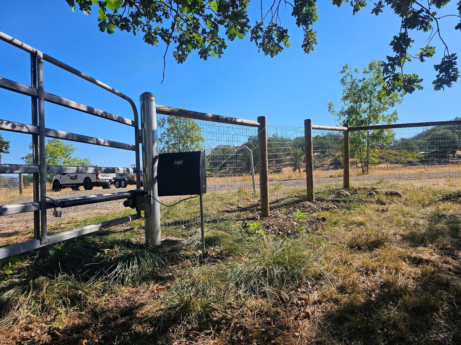 Post-N-Rail fencing with keypad entry pedestal at an automated farm style gate